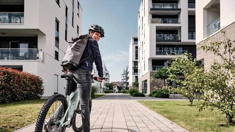 Eine JobRadlerin mit Mountainbike in einer Häuserschlucht Eine JobRadlerin mit Mountainbike in einer Häuserschlucht