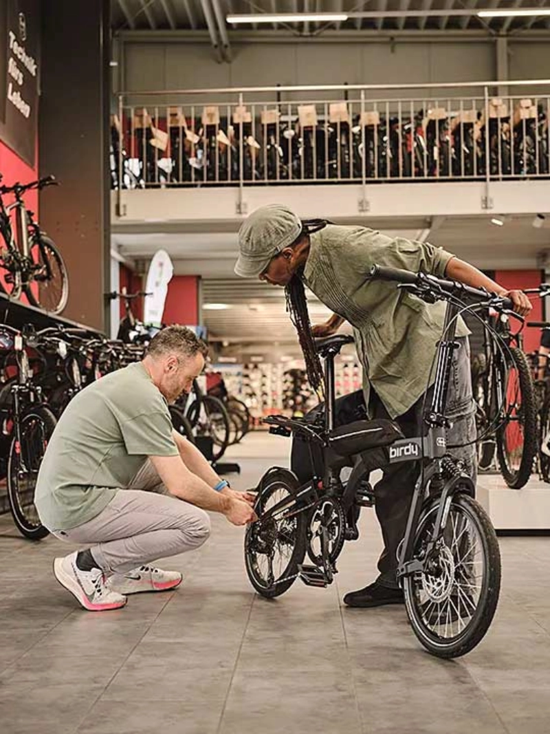 Ein Fachhändler berät eine Kundin mit Klapprad