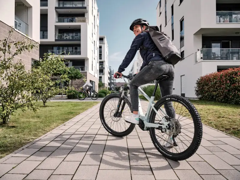 Eine lachende Frau mit Mountainbike in urbaner Umgebung